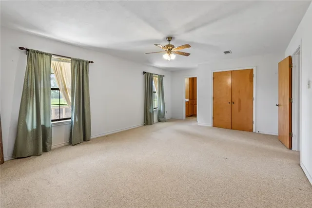 an empty room with closet and a chandelier fan