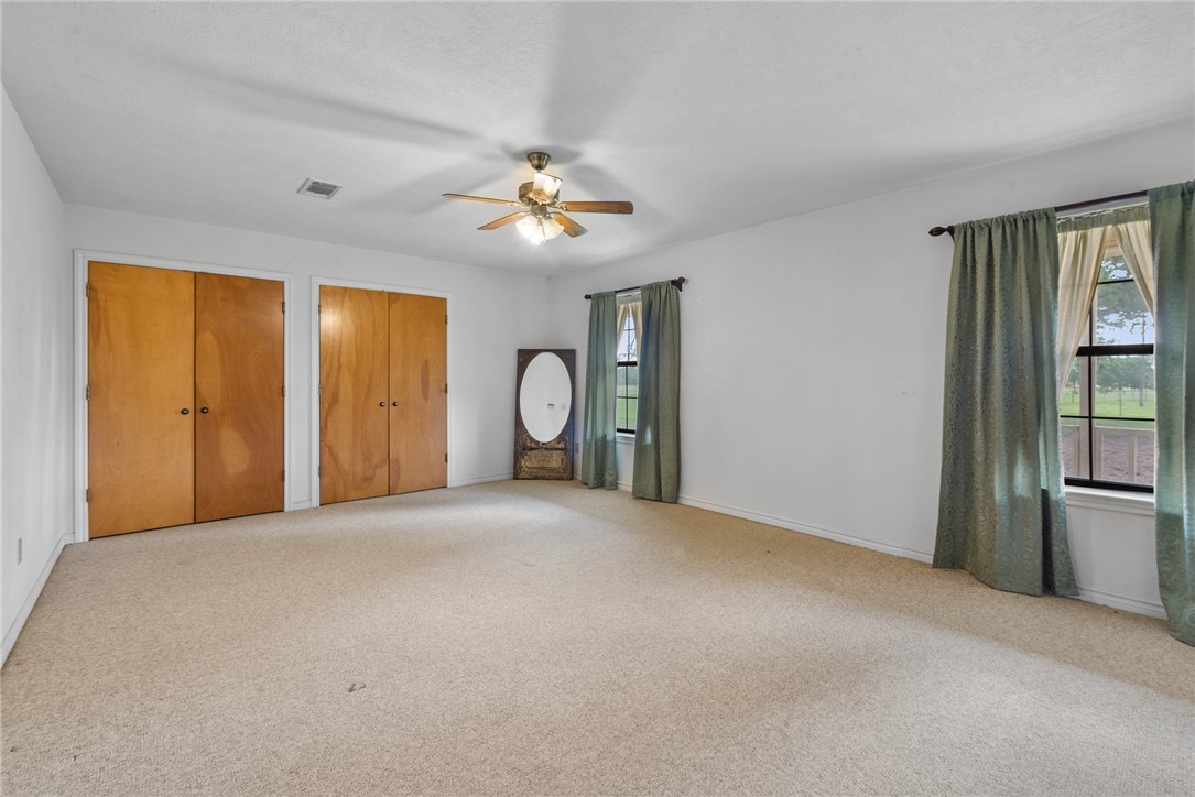 9393 Locke Road Bryan, TX 77808 - Photo 24 of 39 a view of a livingroom with a chandelier fan and windows