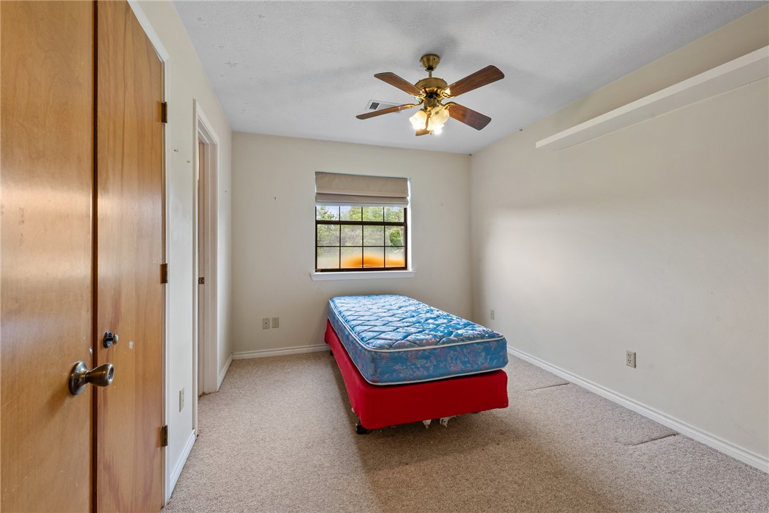 9393 Locke Road Bryan, TX 77808 - Photo 30 of 39 a bedroom with a bed and a chandelier