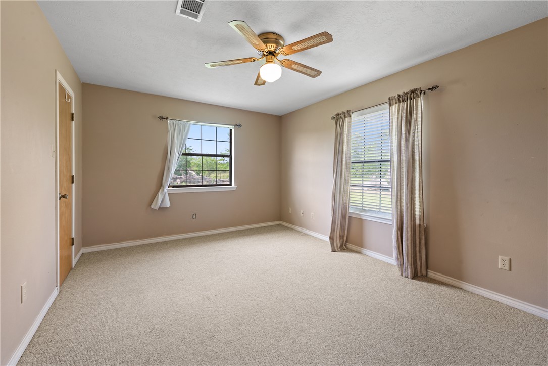 9393 Locke Road Bryan, TX 77808 - Photo 32 of 39 an empty room with windows and fan