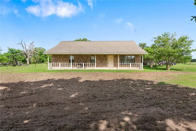 a house with huge green field in front of it