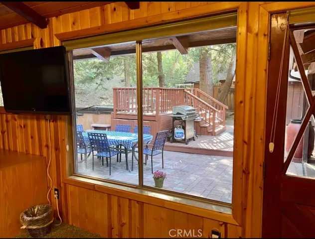 a view of a patio with table and chairs under an umbrella with wooden floor