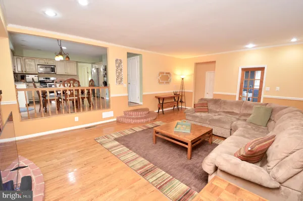 a living room with furniture a dining table and a chandelier