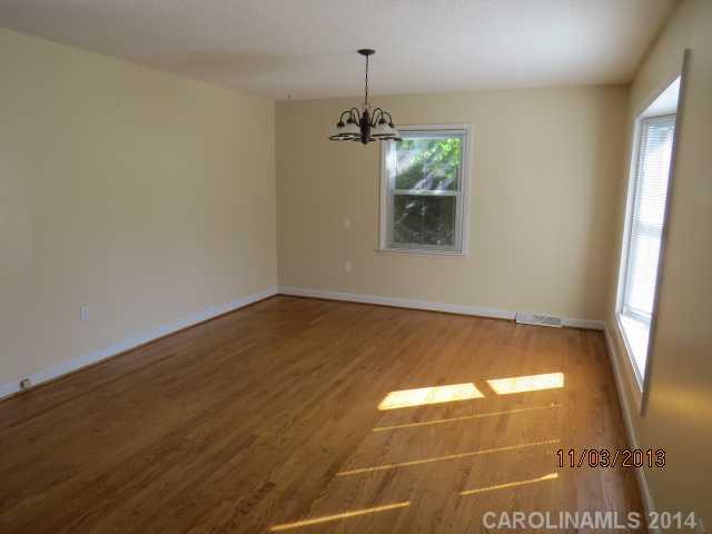 801 Riverwood Road Charlotte, NC 28270 - Photo 5 of 14 an empty room with wooden floor and windows