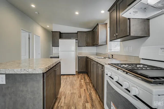 a kitchen with a stove a refrigerator and a sink