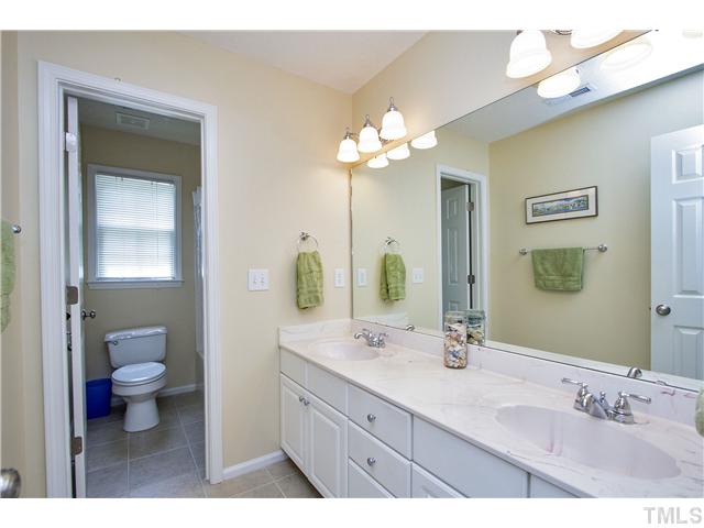 8909 Breeland Way Raleigh, NC 27613 - Photo 19 of 25 a bathroom with a granite countertop sink a toilet and a mirror
