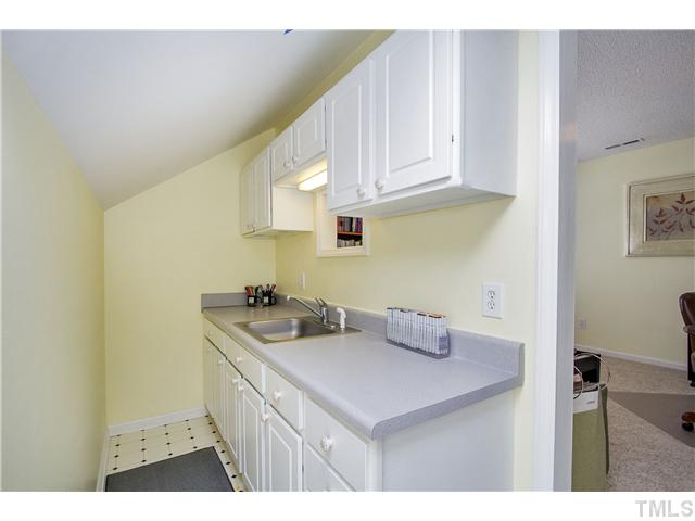 8909 Breeland Way Raleigh, NC 27613 - Photo 21 of 25 a kitchen with a sink and cabinets
