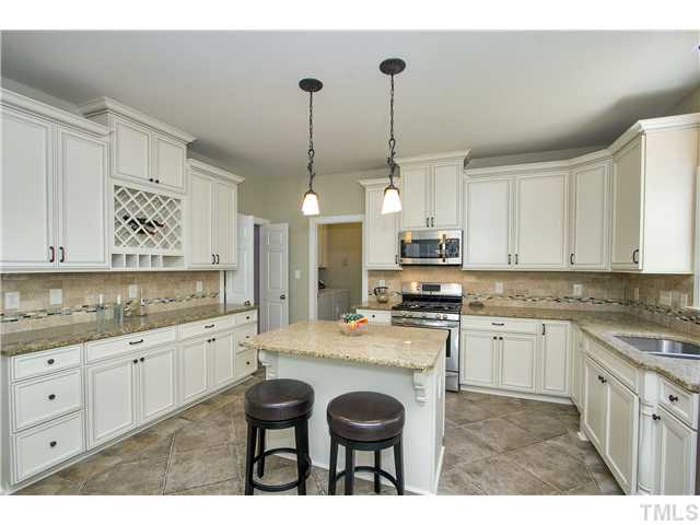 8909 Breeland Way Raleigh, NC 27613 - Photo 9 of 25 a kitchen with granite countertop a sink a counter space appliances and cabinets