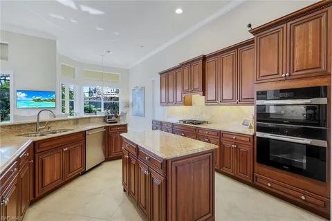 a kitchen with granite countertop a sink a counter top space and stainless steel appliances
