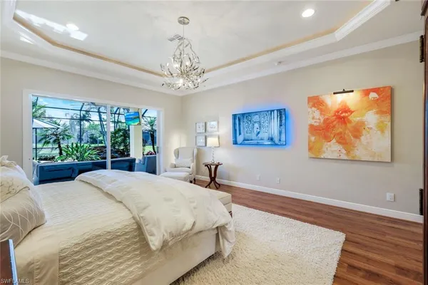 a spacious bedroom with a bed and a chandelier