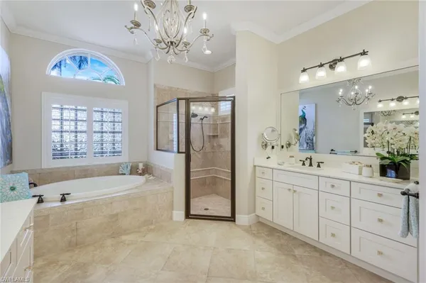 a bedroom with a large bed and a chandelier