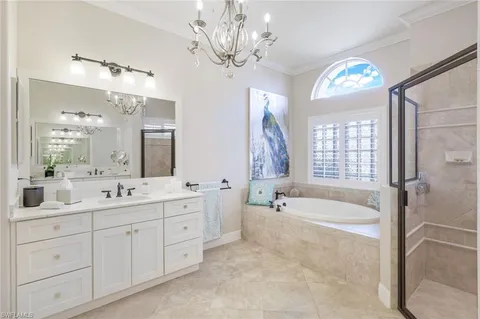 a spacious bathroom with a tub a double vanity sink a vanity a window and a mirror