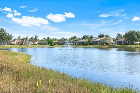 a view of a white house with a yard and potted plants