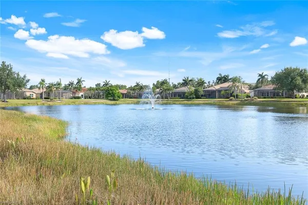 a view of a white house with a yard and potted plants