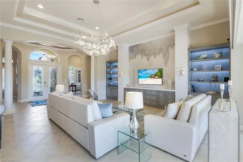 a living room with furniture and a chandelier