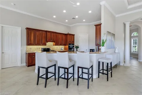a kitchen with kitchen island granite countertop wooden cabinets and chairs
