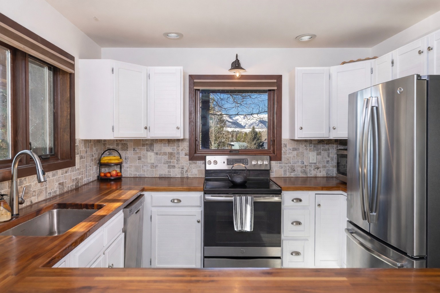 a kitchen with stainless steel appliances granite countertop a sink stove and refrigerator