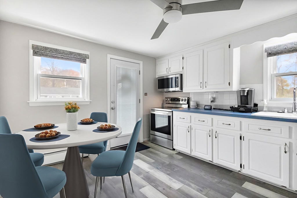 2 Campus Road Methuen, MA 01844 - Photo 6 of 19 a kitchen with stainless steel appliances granite countertop a stove a sink dishwasher a dining table and chairs with wooden floor