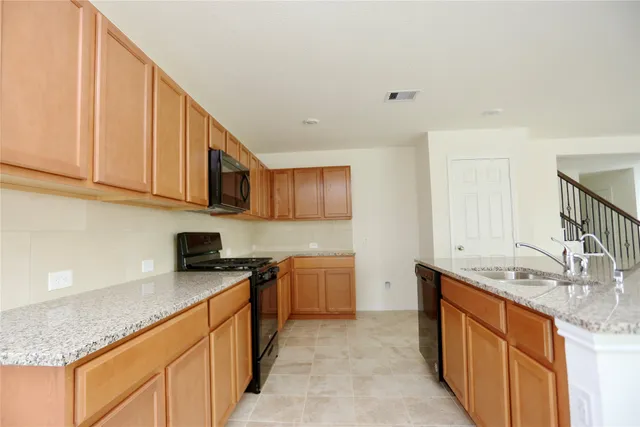 a kitchen with stainless steel appliances granite countertop a sink stove and cabinets