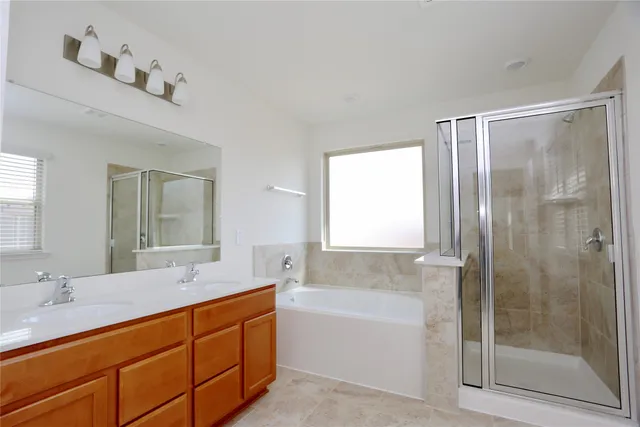 a bathroom with double vanity sinks and a bathtub