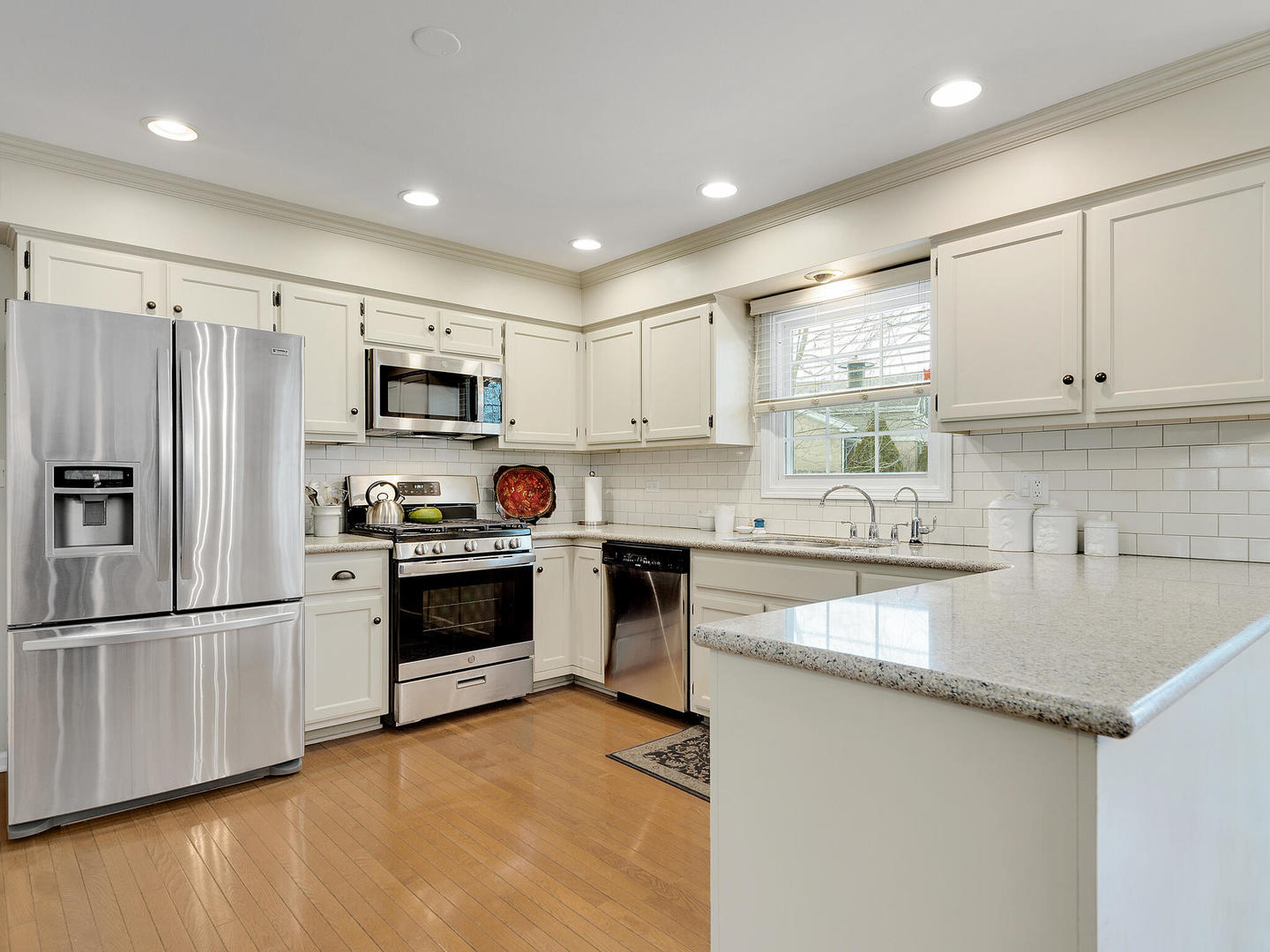 27W626 Garys Mill Road Winfield, IL 60190 - Photo 9 of 23 a kitchen with kitchen island granite countertop a stove top oven a sink dishwasher a refrigerator and cabinets with wooden floor
