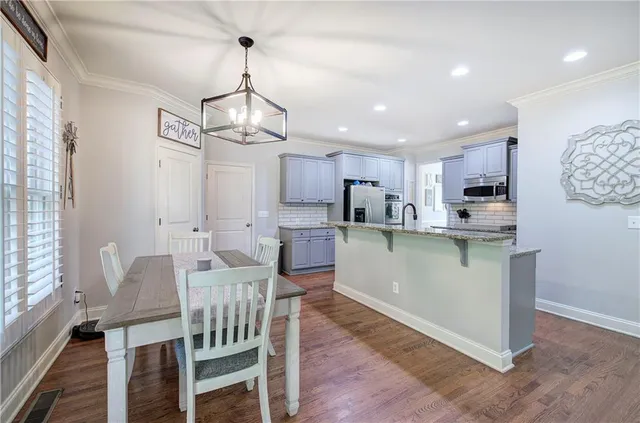 a view of kitchen with refrigerator and wooden floor