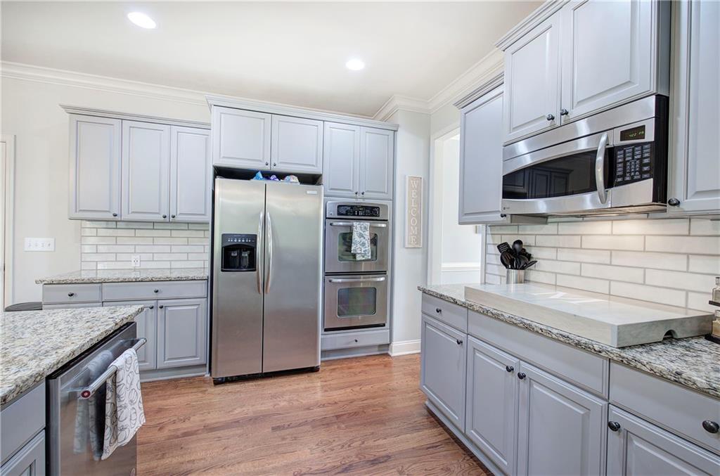 12 Autumn Wood Drive Cartersville, GA 30120 - Photo 12 of 48 a kitchen with stainless steel appliances granite countertop a refrigerator a stove a sink and dishwasher wooden cabinets with wooden floor