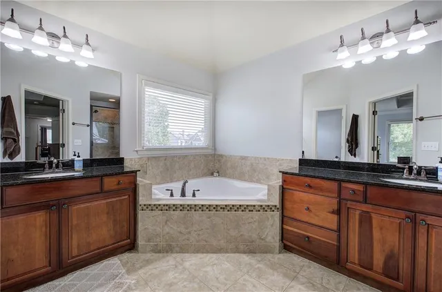 a bathroom with a tub sink and mirror