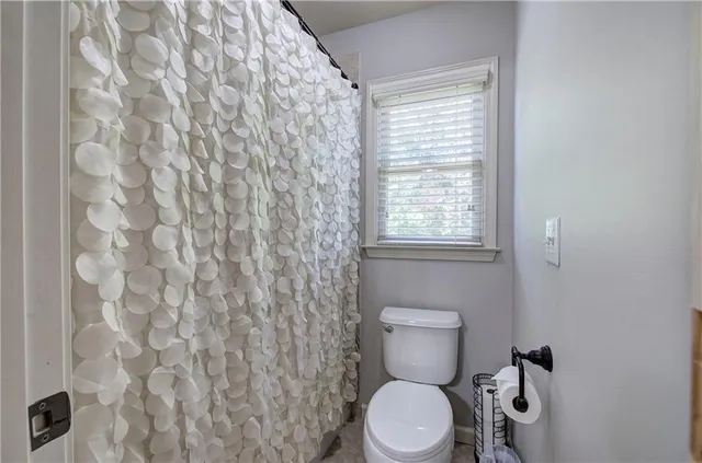 a white toilet sitting next to a shower curtain