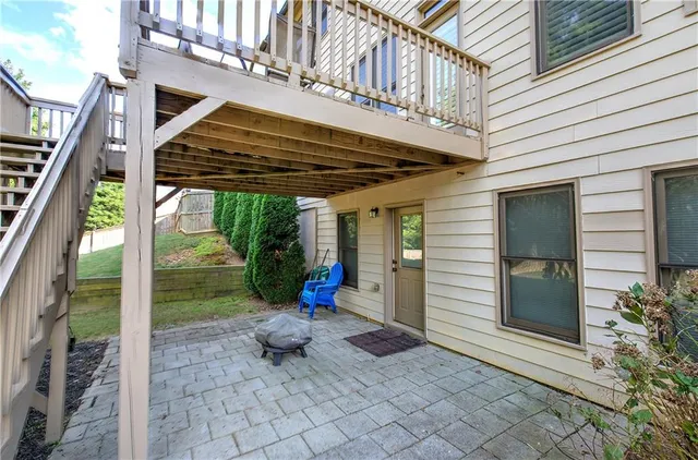 a view of a porch with a floor to ceiling window and potted plants
