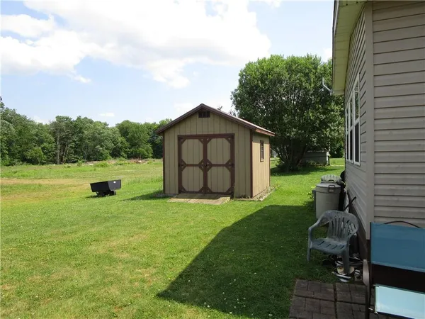 a backyard of a house with barbeque oven and garden
