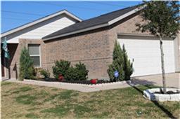 3142 Aspen Fair Trail Spring, TX 77389 - Photo 2 of 22 This photo shows a single-story brick home with a two-car garage. The front yard features a neatly landscaped garden with shrubs and a small tree, set against a backdrop of blue sky.