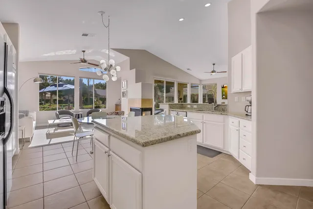 a kitchen with stainless steel appliances granite countertop a sink a stove and a refrigerator