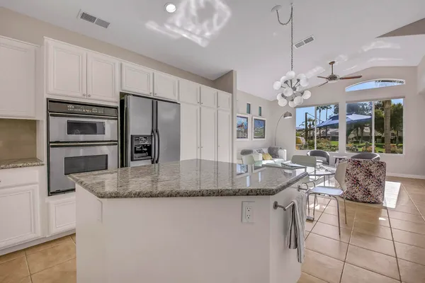 a kitchen with granite countertop white cabinets and stainless steel appliances