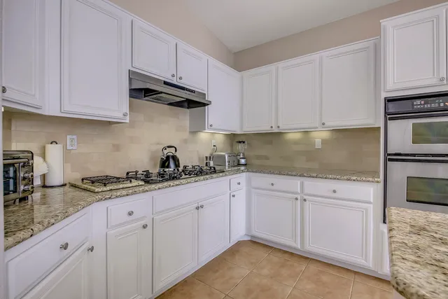 a living room with furniture and floor to ceiling windows