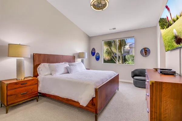 a bedroom with a bed and a flat screen tv