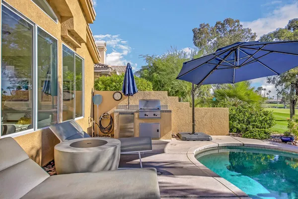 a view of a patio with table and chairs under an umbrella
