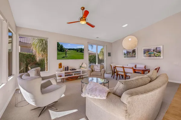 a living room with furniture a fireplace and a chandelier