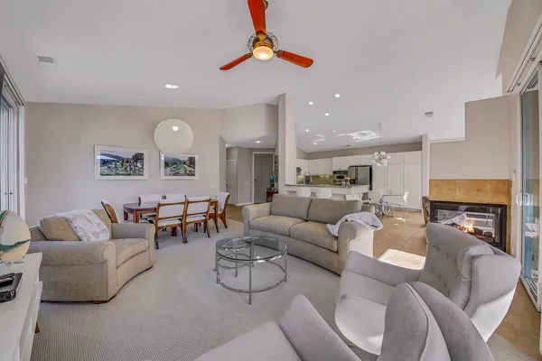 a living room with furniture a fireplace and kitchen view