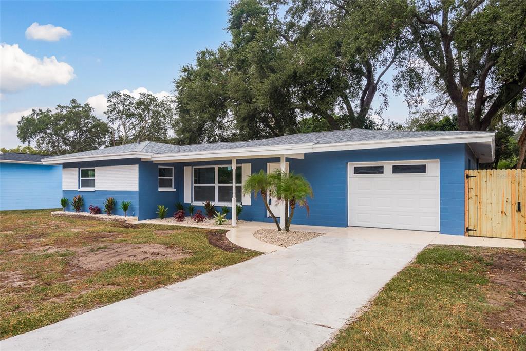 11522 Ridge Road Largo, FL 33778 - Photo 1 of 1 a front view of a house with a garden and trees