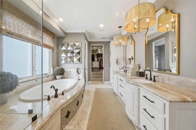 a spacious bathroom with a granite countertop tub a double vanity sink and a large mirror