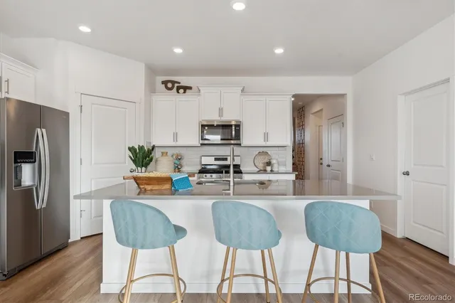 a kitchen with stainless steel appliances granite countertop a refrigerator and a stove top oven