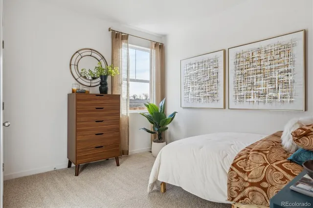 a bed sitting in a bedroom next to a window and a dresser