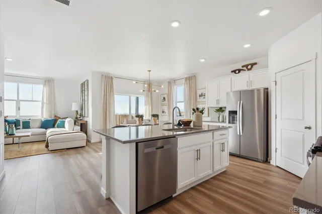 a kitchen with stainless steel appliances granite countertop a lot of counter space and wooden floors