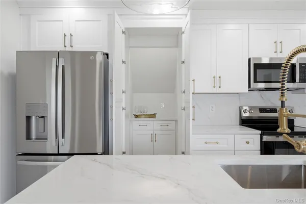 a kitchen with stainless steel appliances granite countertop a refrigerator and a stove top oven
