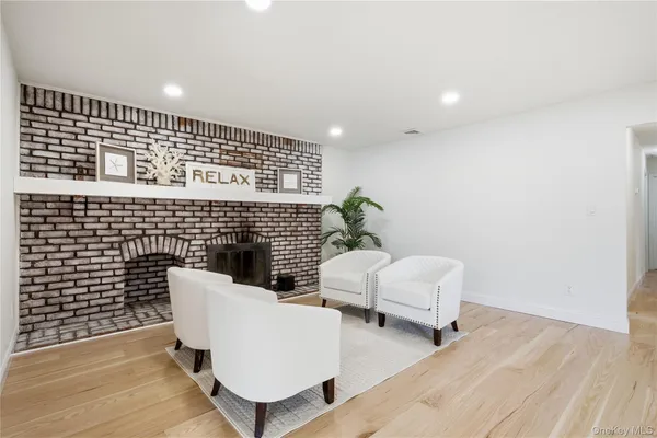 a living room with couches chairs and wooden floor
