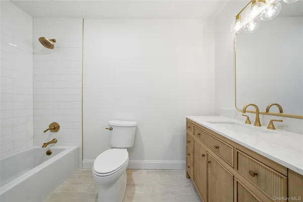 a bathroom with a granite countertop toilet a sink and bathtub