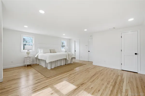 a spacious bedroom with a bed and a painting on the wall