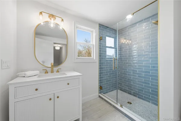 a bathroom with a double vanity sink mirror and shower
