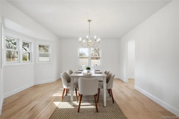 a dining room with furniture a chandelier and wooden floor